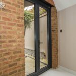 Glass Front Door to modern house with brick layout