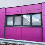 Commercial black windows installed by First Windows with pink walls wide view